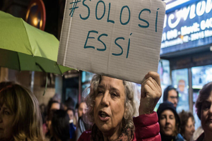 A woman holds a placard saying ‘'only yes is yes' 
