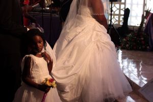 Little girl in a white dress next to a bride